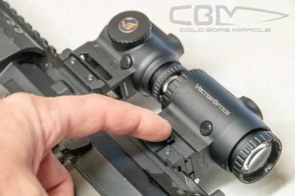 pushing the spring-loaded button to fold the magnifier out of the way
