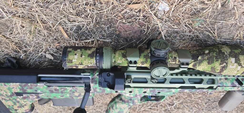 Frenzy FLEX 24x29 MRT mounted on a camouflaged rifle next to the scope Frenzy FLEX 24x29 MRT mounted on a camouflaged rifle next to the scope