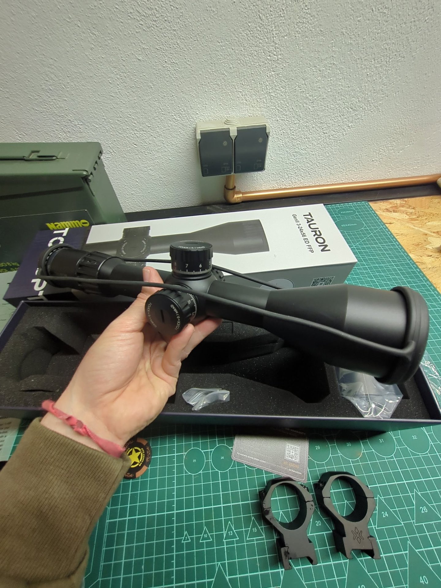 Tauron GenII 3-24x56 ED FFP rifle scope held in hand next to its box